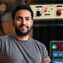 Portrait of Marcus Lee, an arcade enthusiast, next to a restored joystick.